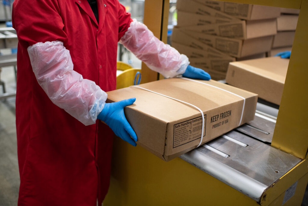 employee handling packaged poultry