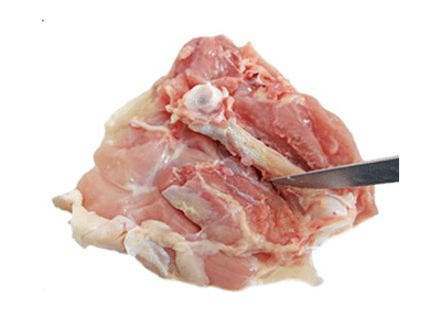 Raw chicken thigh being de-boned