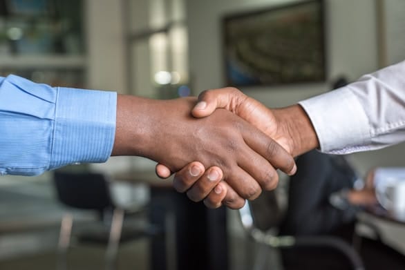 A handshake between two men in dress shirts